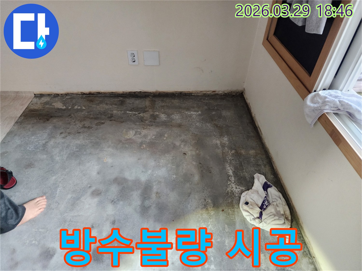 이 이미지는-남양주 오남읍의 한 건물에서-바닥과 벽면 경계에-습기와 곰팡이가 발생한-누수 현장을-보여주며-방수 불량 가능성을-시사합니다