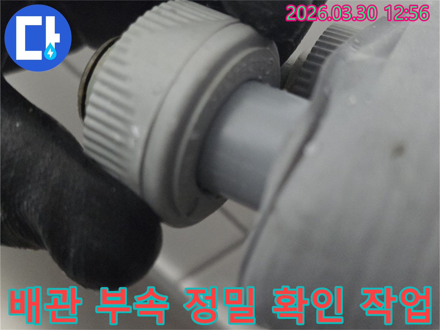 누수 발생 가능성이 높은 배관 부속품의 상태를 육안으로 확인하고 있는 전문가의 모습