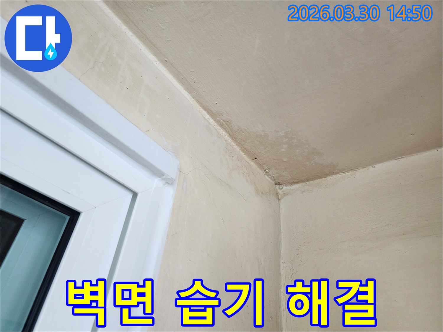 창문 옆-벽면과 천장 경계에 생긴-누수 흔적과-습기로 인한 변색을-보여주는 사진입니다