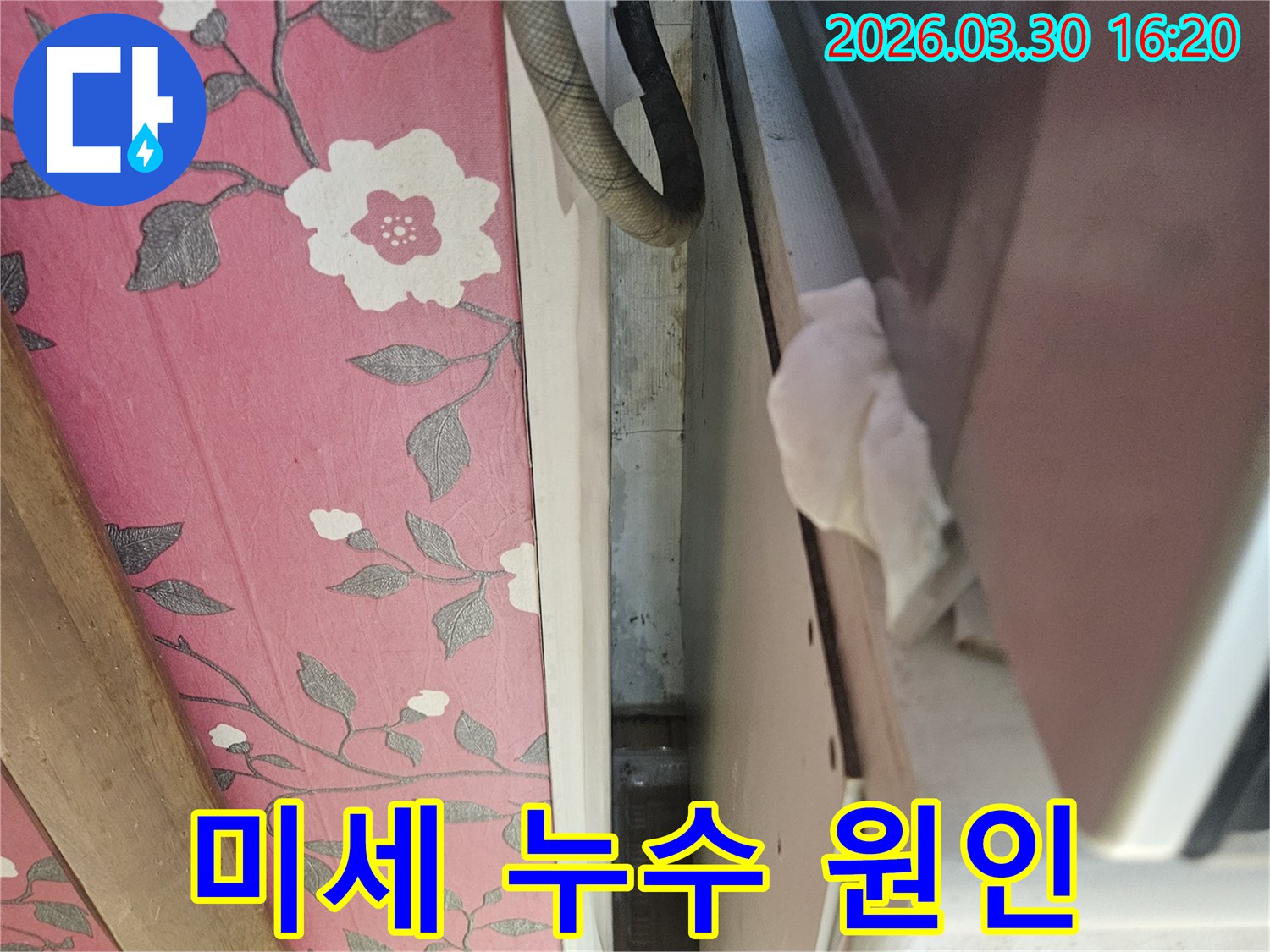 이 이미지는-천장-틈새에서-발견된-미세한-누수-현장을-보여주며-젖은-종이로-누수-여부를-확인하고-있습니다
