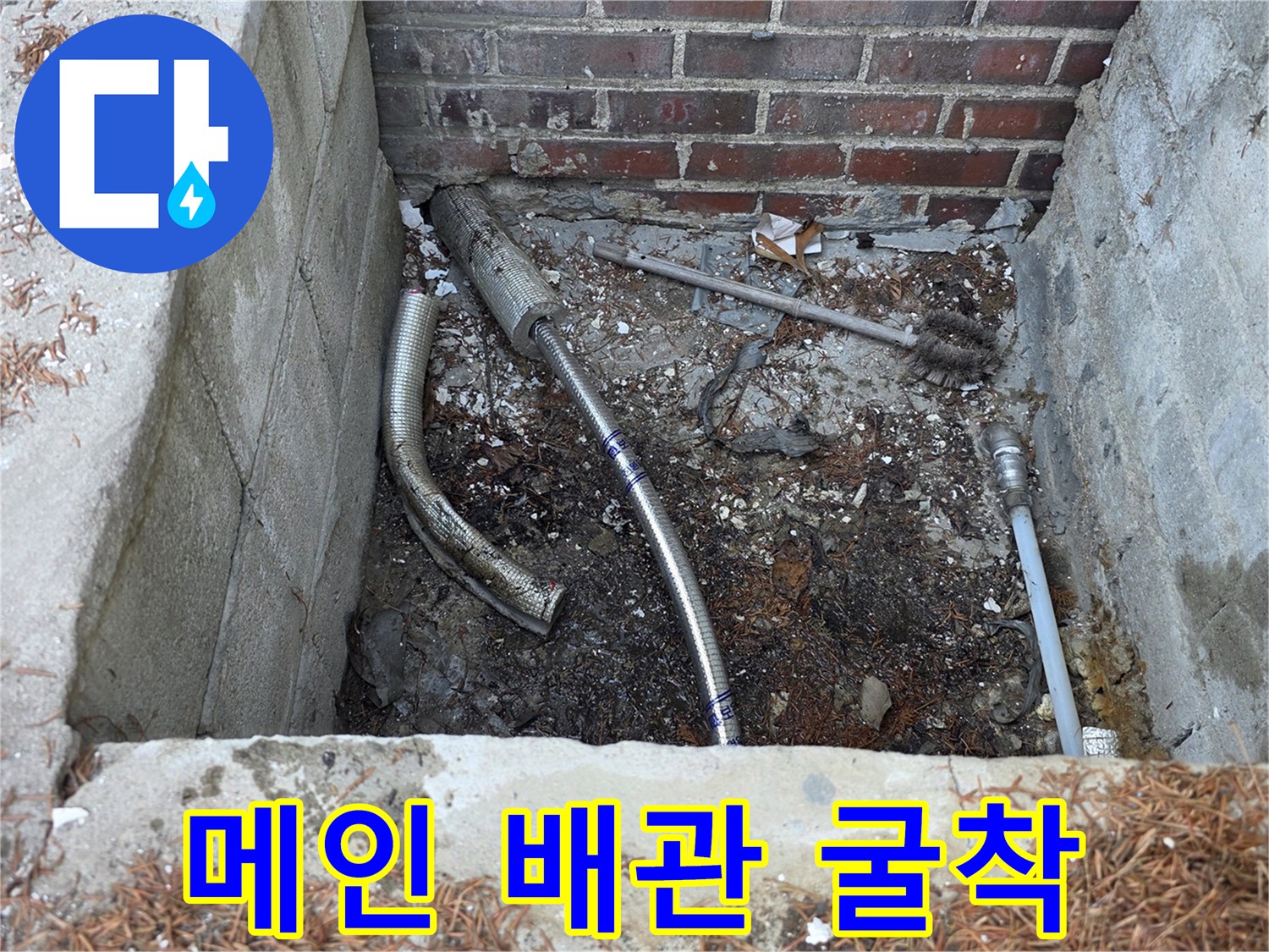 벽돌 구조물 아래 드러난 수도 배관의 굴착 작업 현장