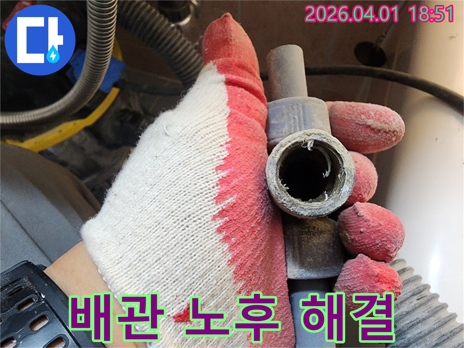 작업용 장갑을 낀 손으로-오래되어 부식된 배관을 들고-누수 해결 과정을 설명하는 모습