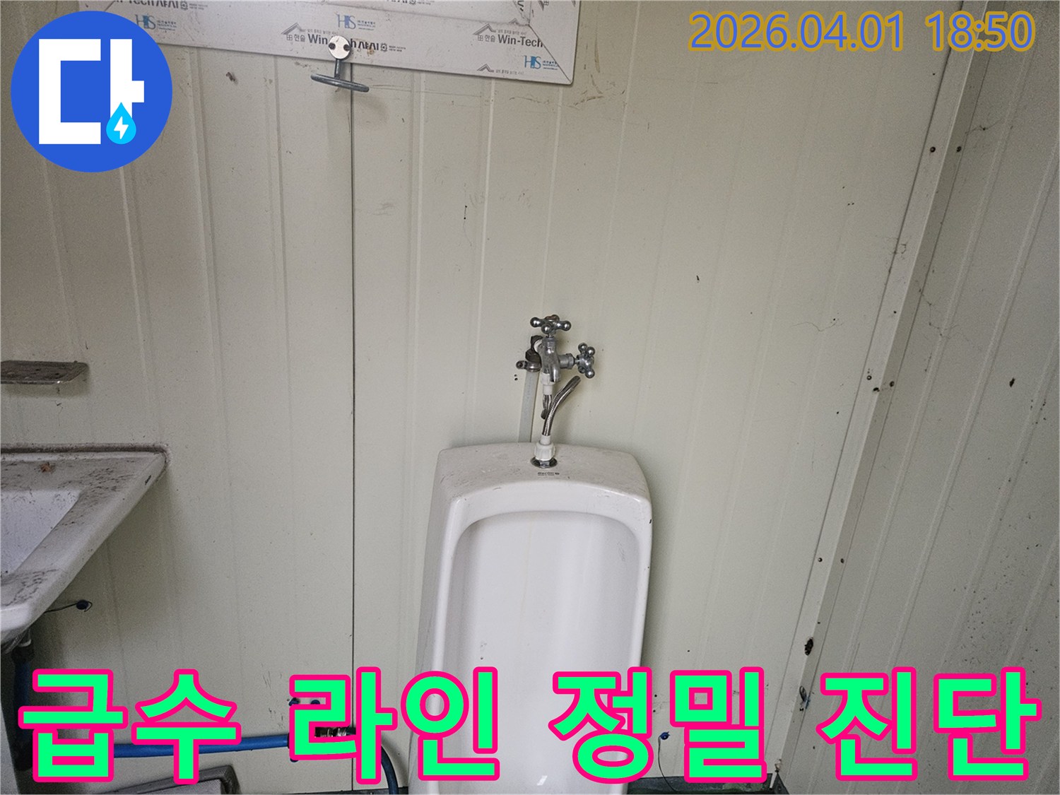 가설 화장실 소변기 상단 수도꼭지와-하단 급수 호스 연결 부위의-전반적인 급수 라인 상태를 정밀하게 진단하는 모습