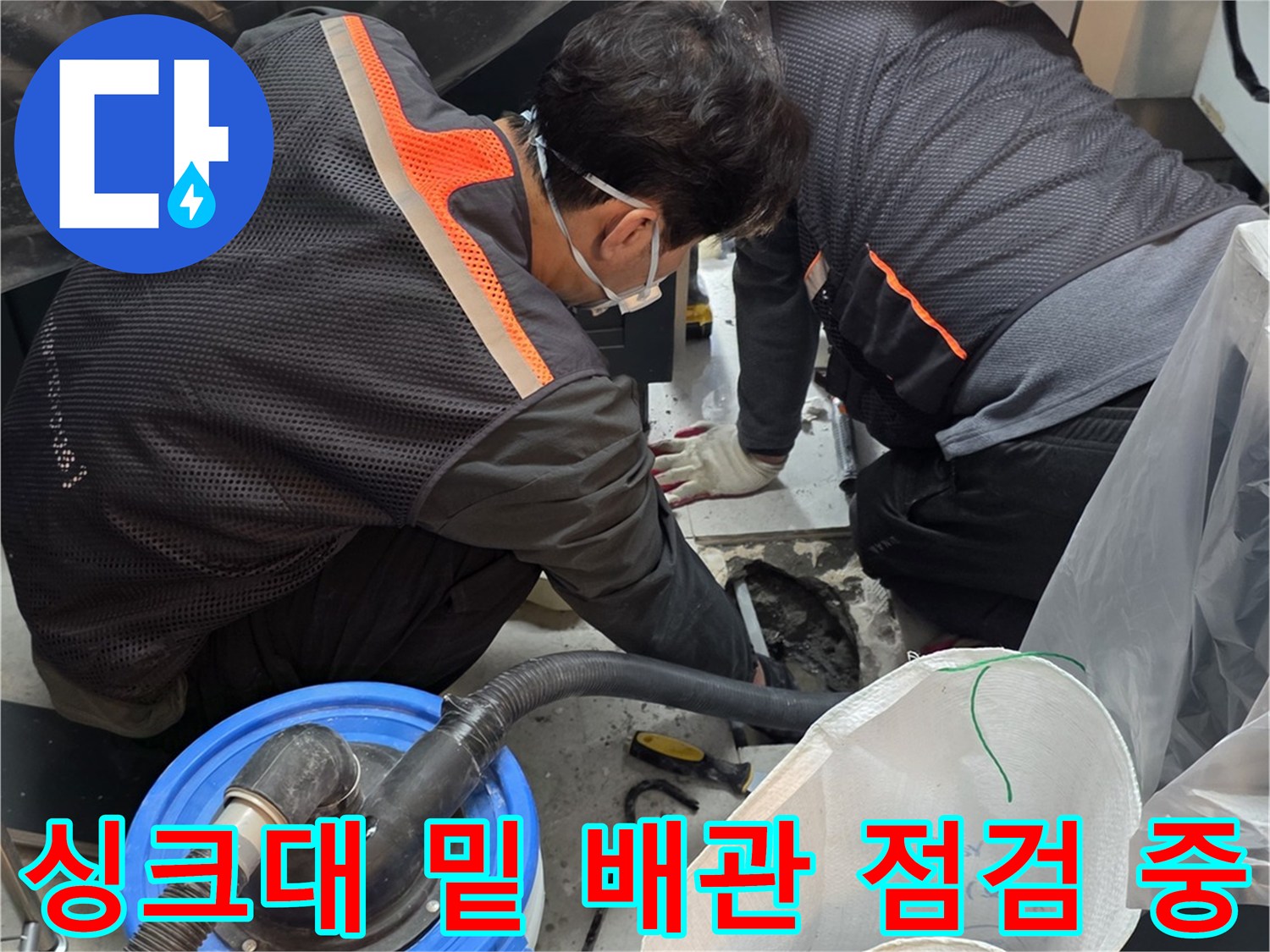 싱크대 하단 공간의 보양 작업과 집진 장비 배치 모습