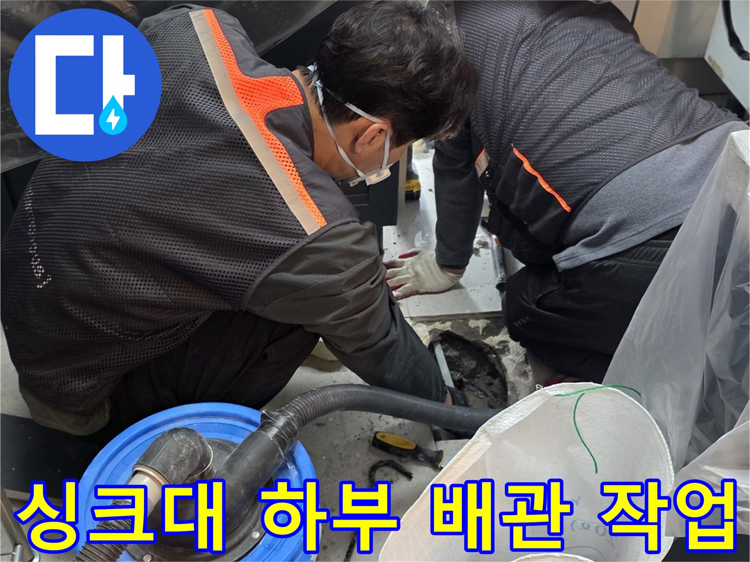 싱크대 하단 부근에서 진행되는 배관 수선 및 집진 작업 현장