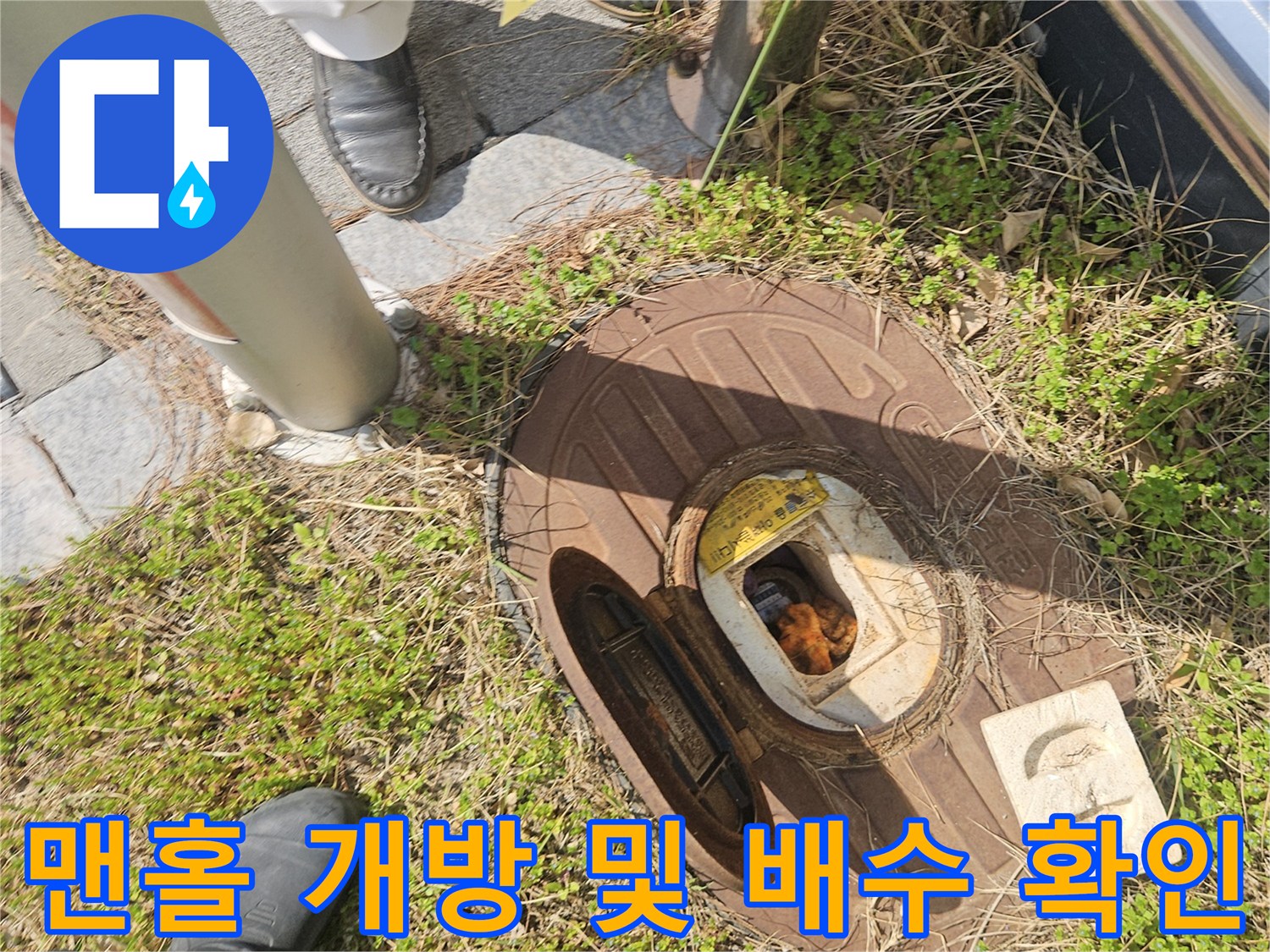 작업자가 맨홀 내부의 배수 상태를 점검하기 위해 접근한 모습입니다.