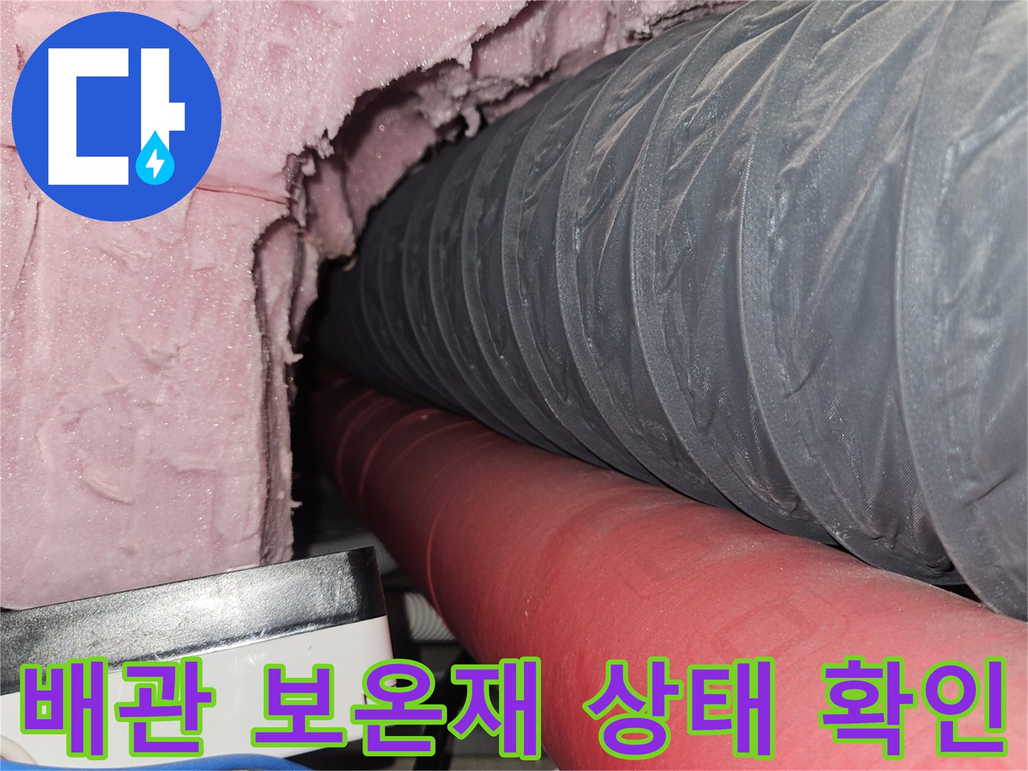 회색 주름관과 빨간 배관이 지나가는 설비실 내부 모습
