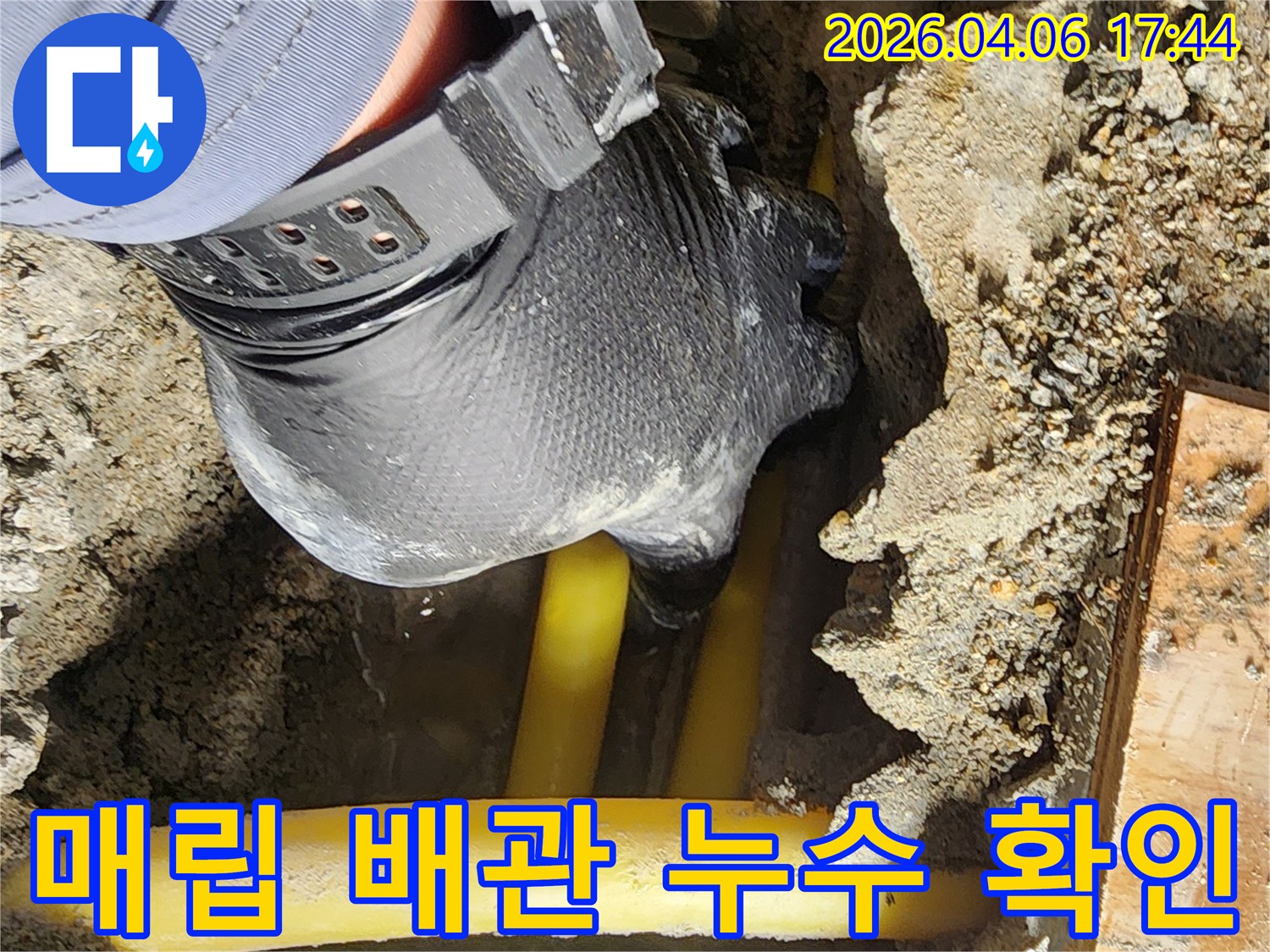 전문 엔지니어가-땅속에 묻힌 배관의 누수 여부를-손으로 직접 확인하며 점검하고 있습니다.