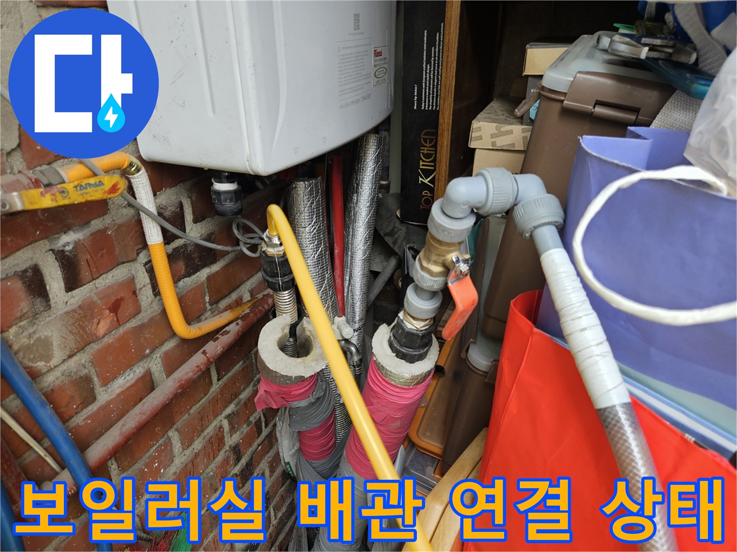 보일러실 내부의 노란색 및 은색 보온재로 감싸진 배관 연결 부위 모습