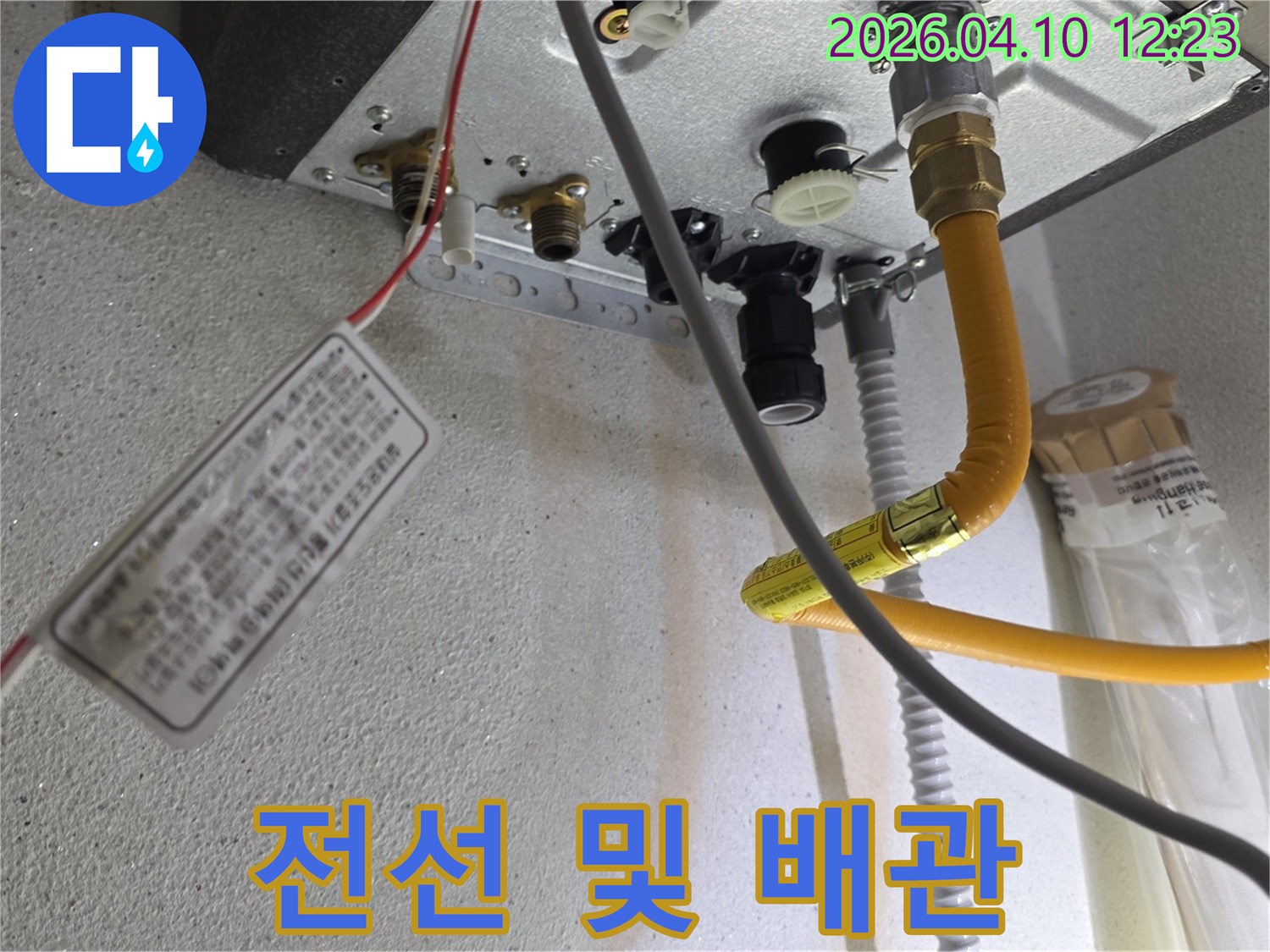 보일러 하단에 연결된 다양한 배관과 전기 배선들이 복잡하게 얽힌 모습입니다.