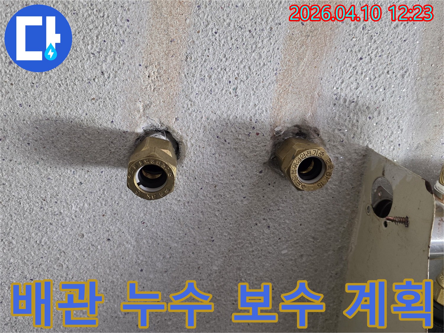 콘크리트-벽에-매립된-수도-배관-연결-부위에서-발생한-누수를-보수하기-위한-준비-과정을-보여주는-사진