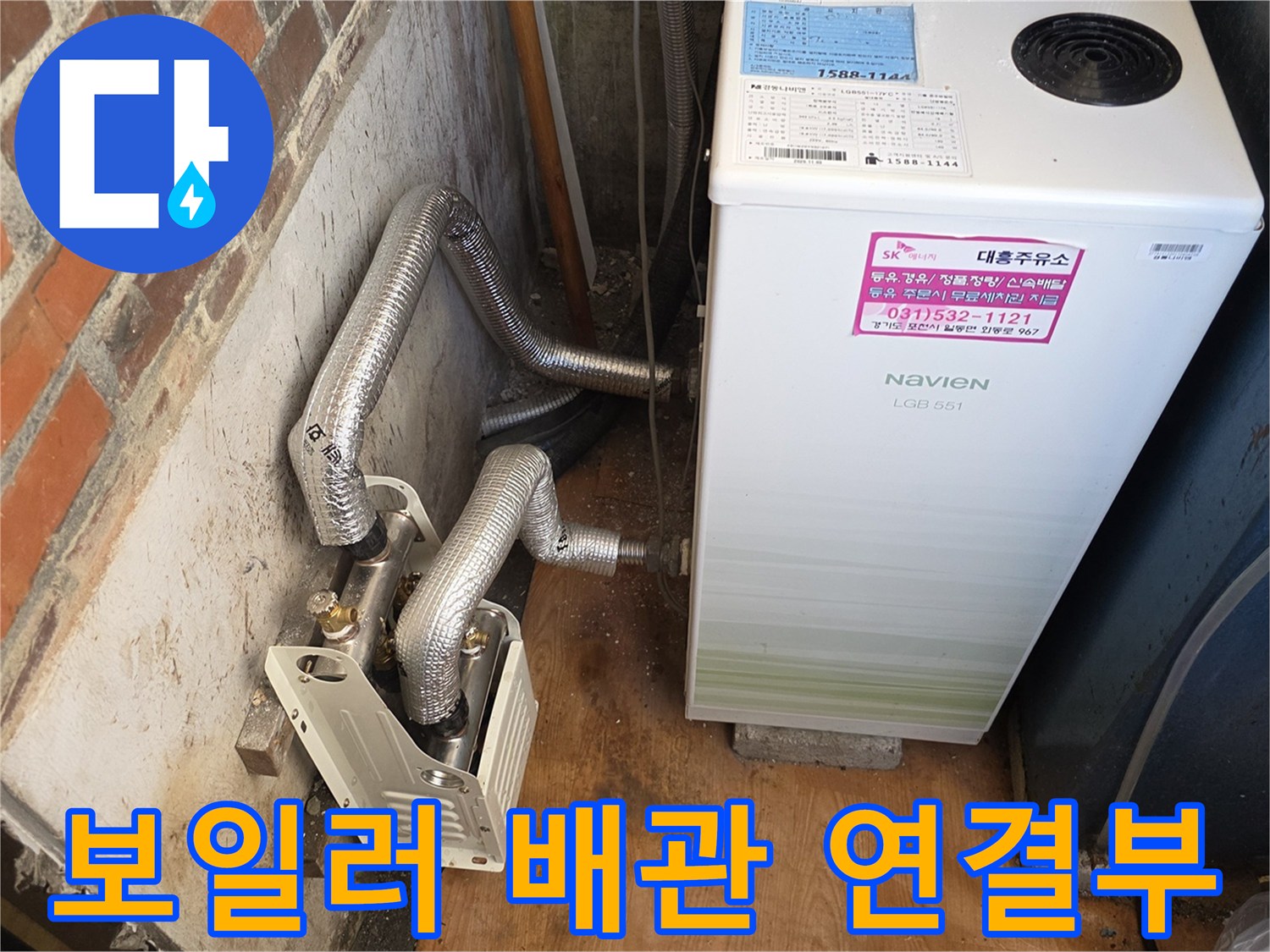 보일러 하단에 위치한 금속 주름관과 연결 부품의 근접 촬영