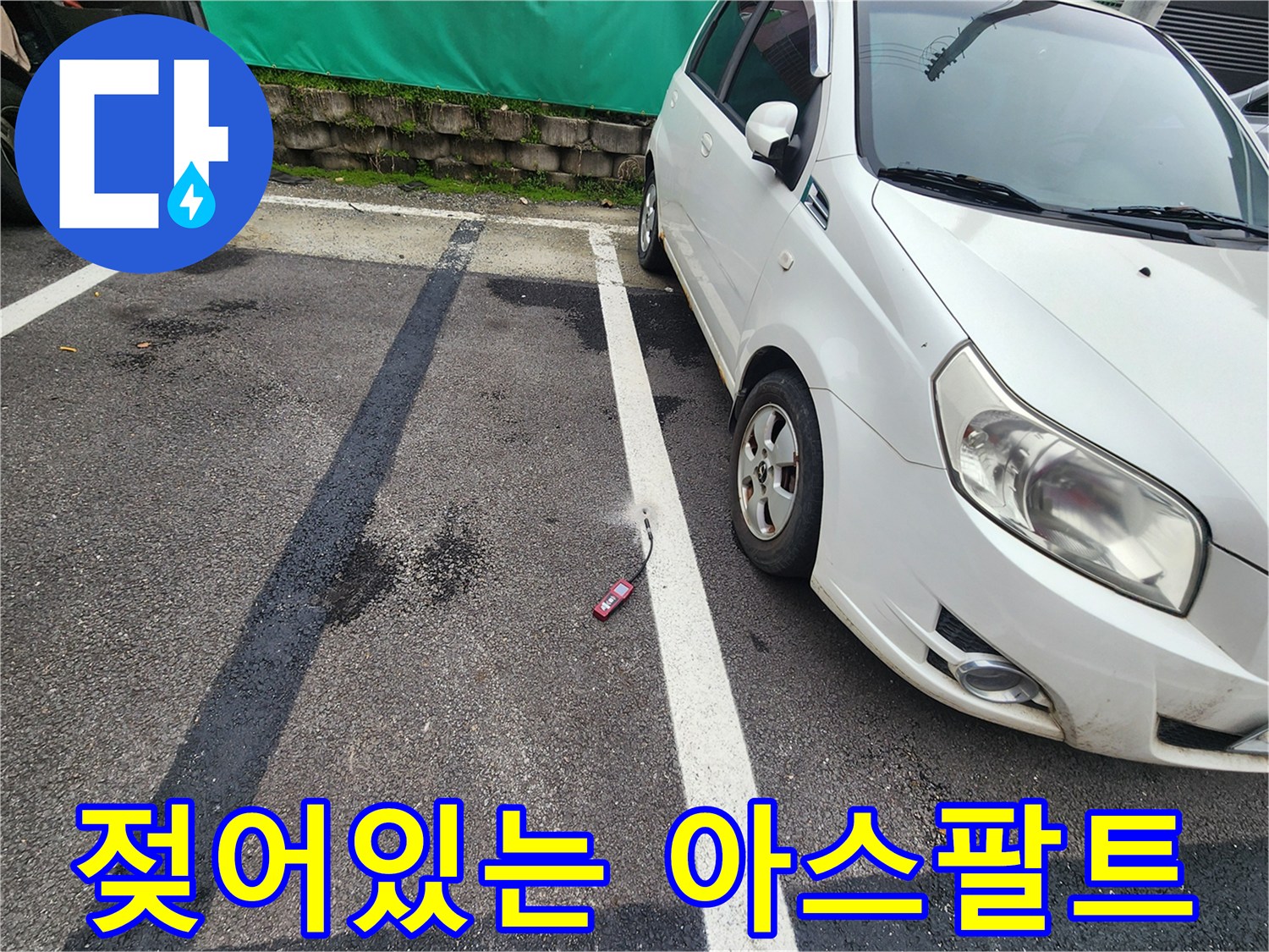 물샘으로 인해 검게 변한 주차장 아스팔트 노면 사진