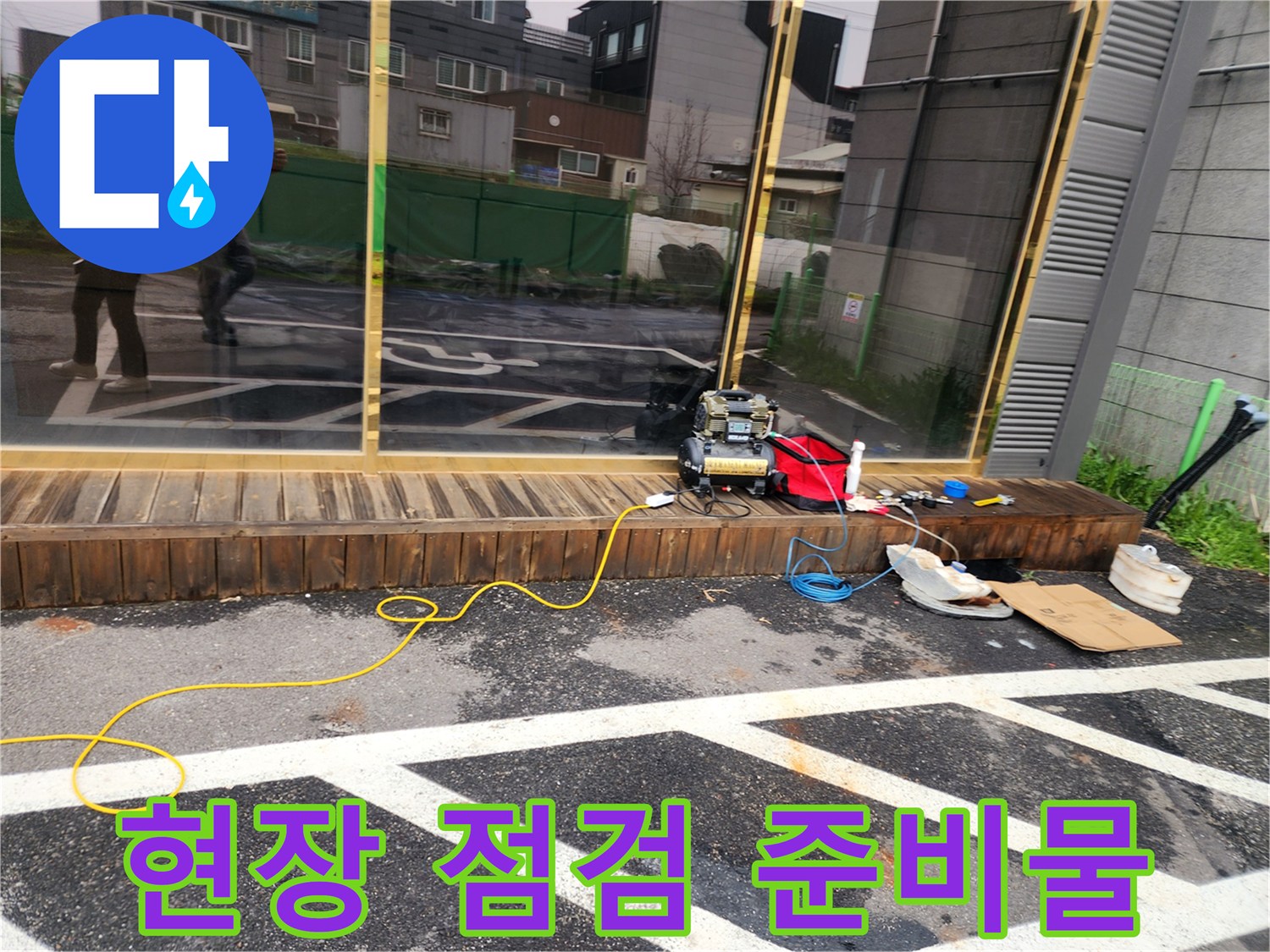 아스팔트 작업 구역 옆에 놓인 누수 진단용 전동 기기와 공구