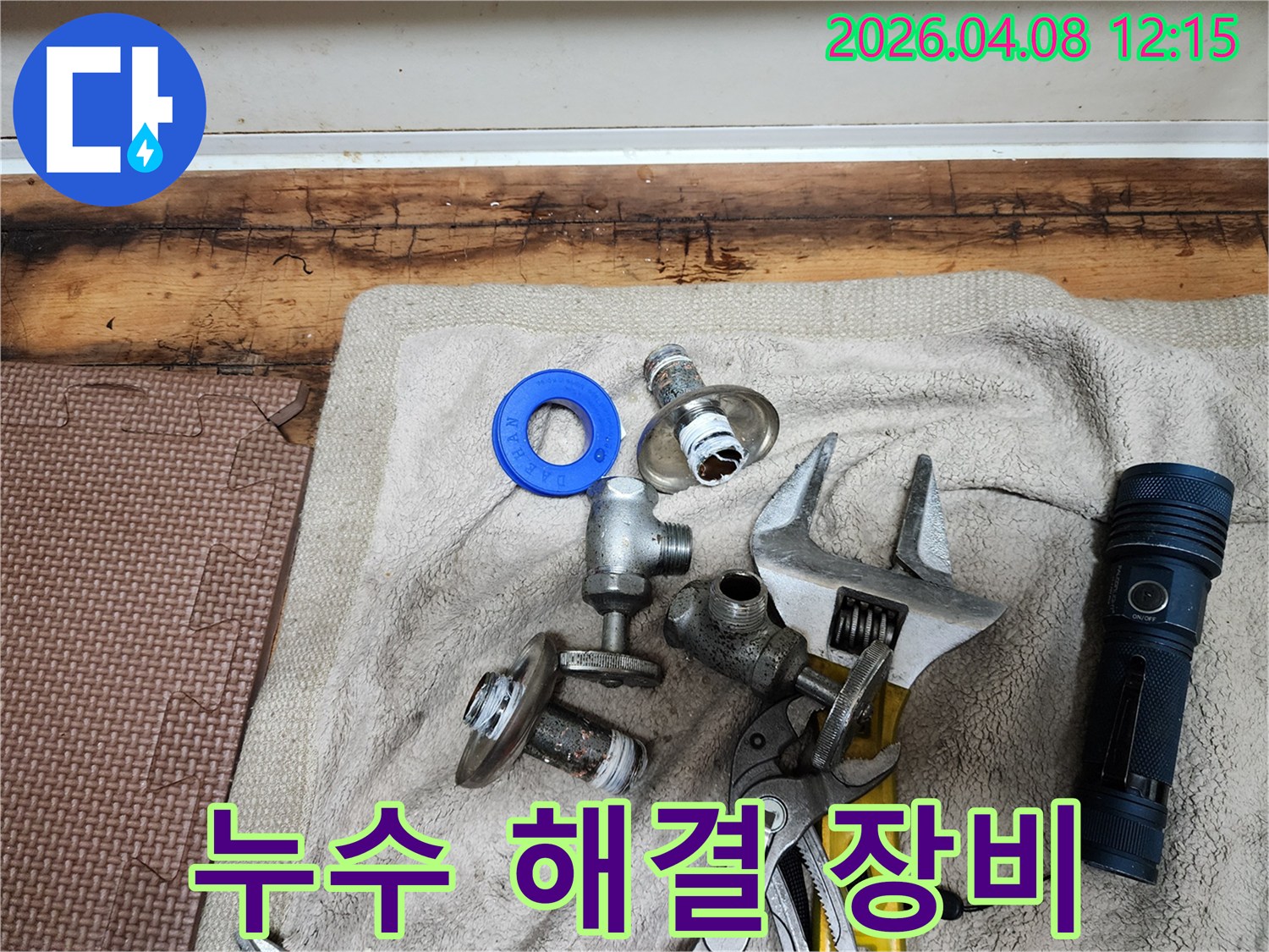 누수 문제를 완벽하게 해결하기 위해-준비된 다양한 전문 장비와-교체용 부품들이-수건 위에 놓여 있습니다