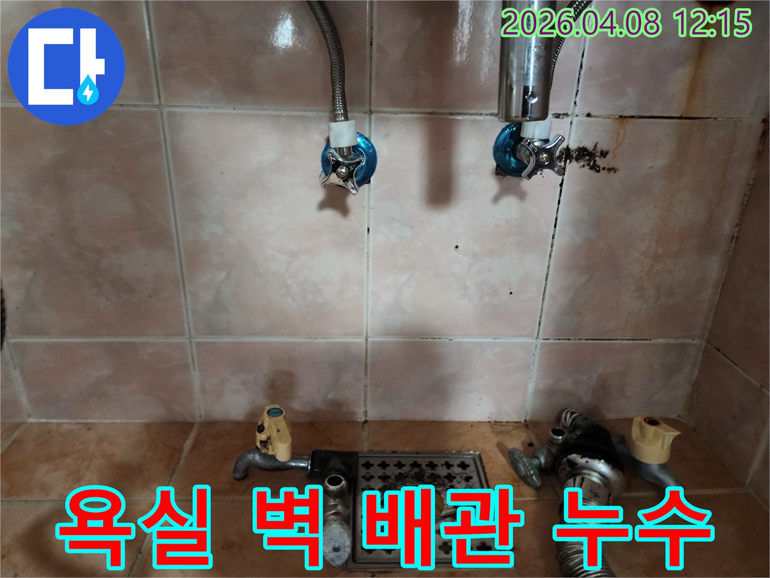 욕실 벽면의 수도 배관 연결 부위에서-물이 새어 나와-벽이 젖고 오염된 현장 사진
