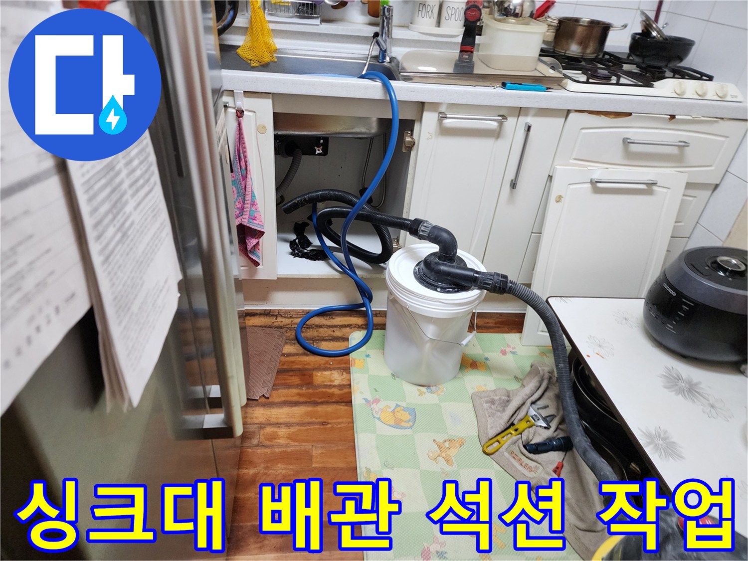 주방 싱크대 하부장 내부-배관 이물질 제거를 위한 석션 장비 가동 중