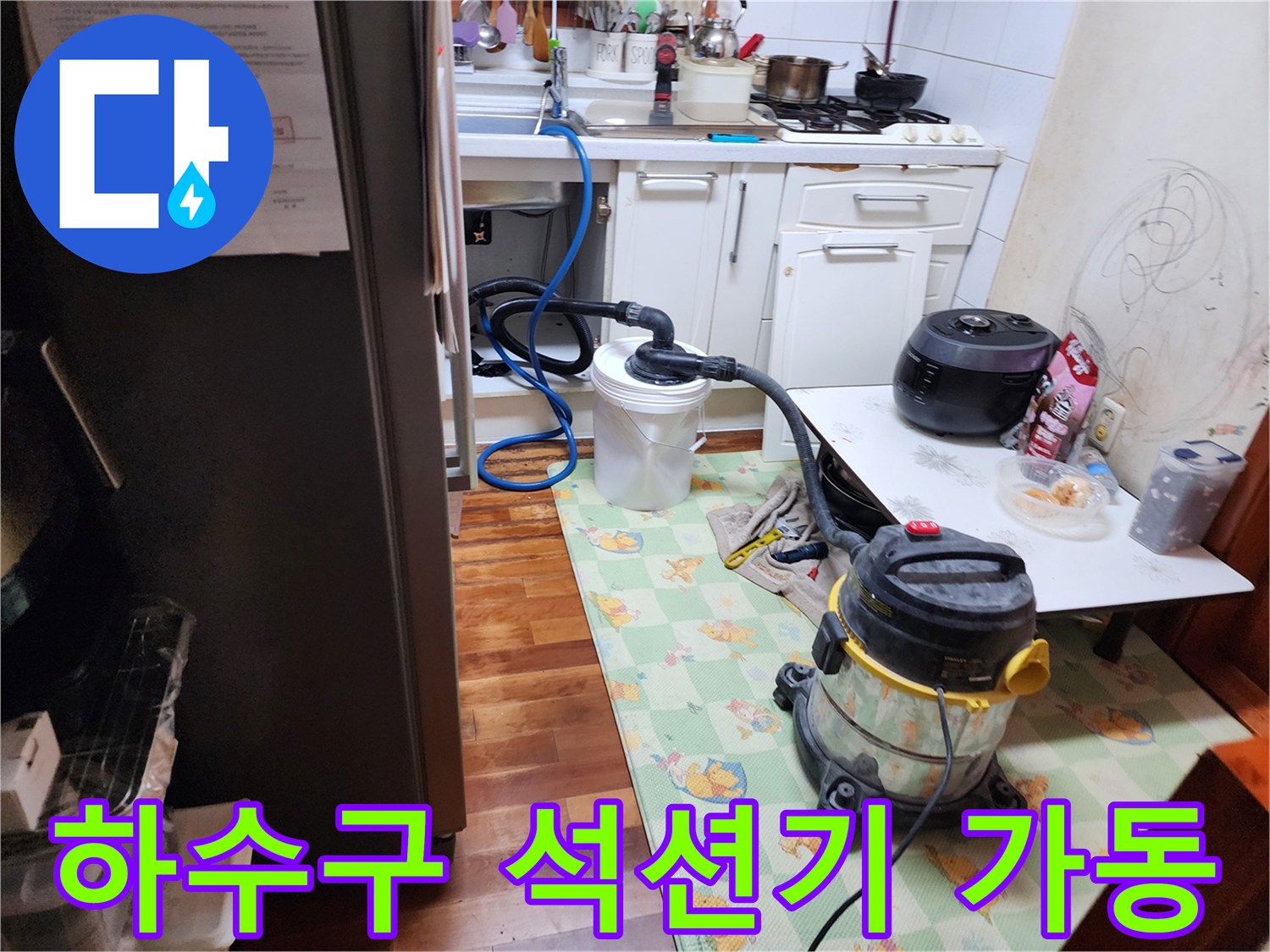 주방 하수구 내부의 오물을 흡입하기 위해 연결된 석션 장비와 배관 호스