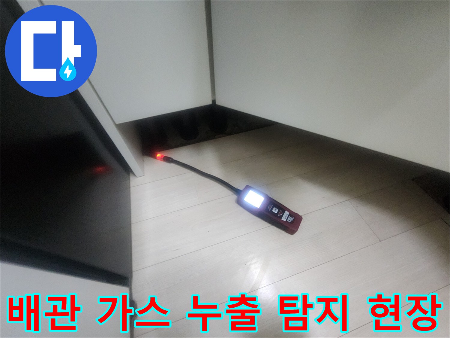 싱크대 밑 어두운 틈새로 들어간 가스 탐지 장비의 모습입니다.