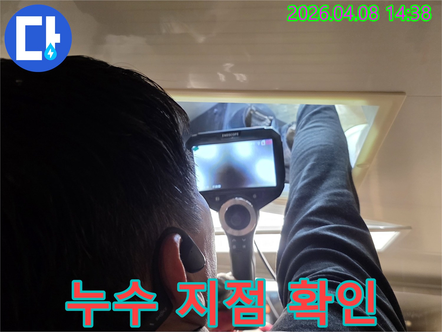 전문 누수 탐지사가 내시경 카메라를 이용해 숨겨진 배관의 누수 지점을 정밀하게 관찰하는 모습