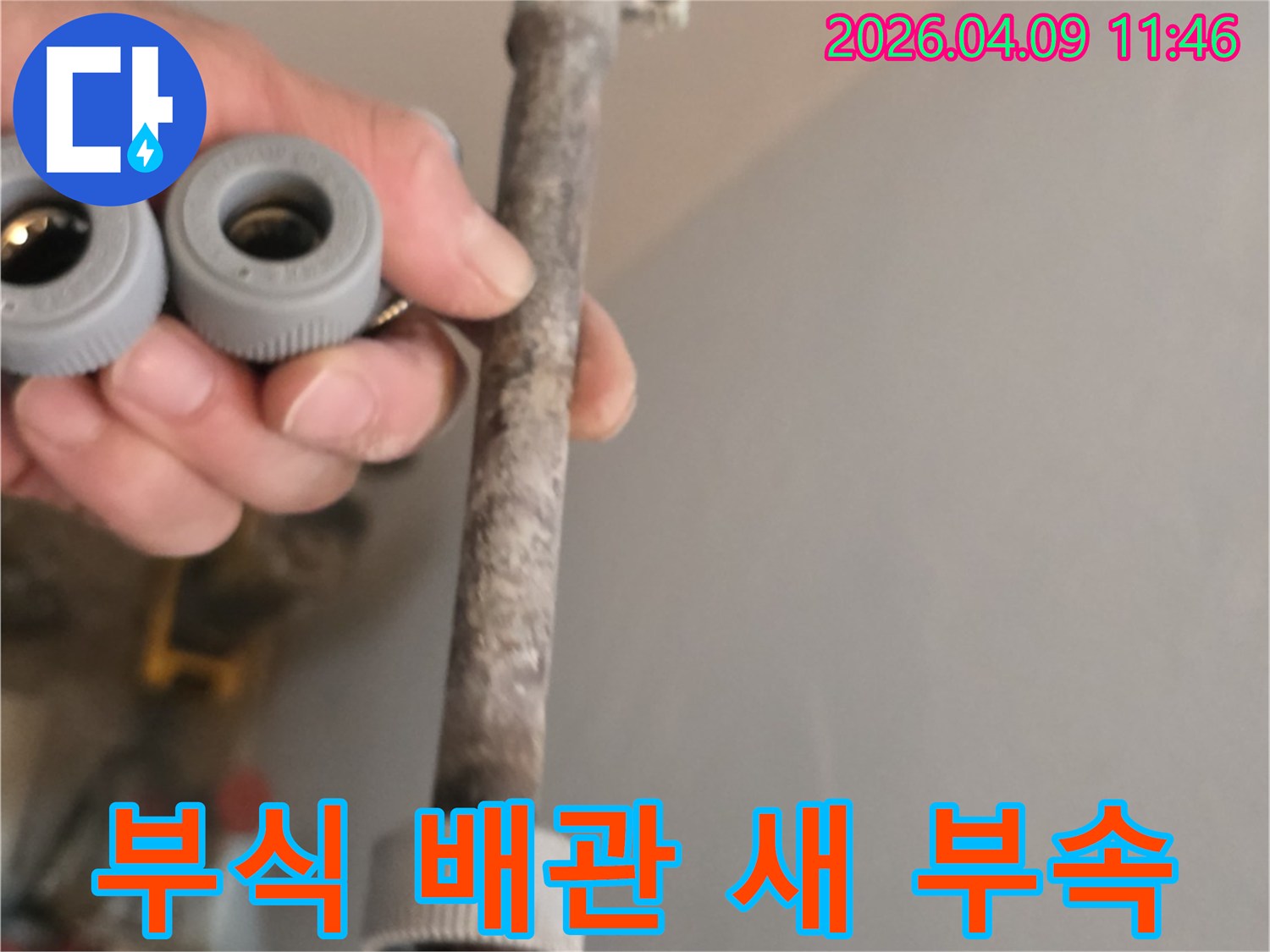 이 사진은-오랜 사용으로 부식된 수도 배관과-교체에 사용될 새 배관 부속을-선명하게 보여줍니다