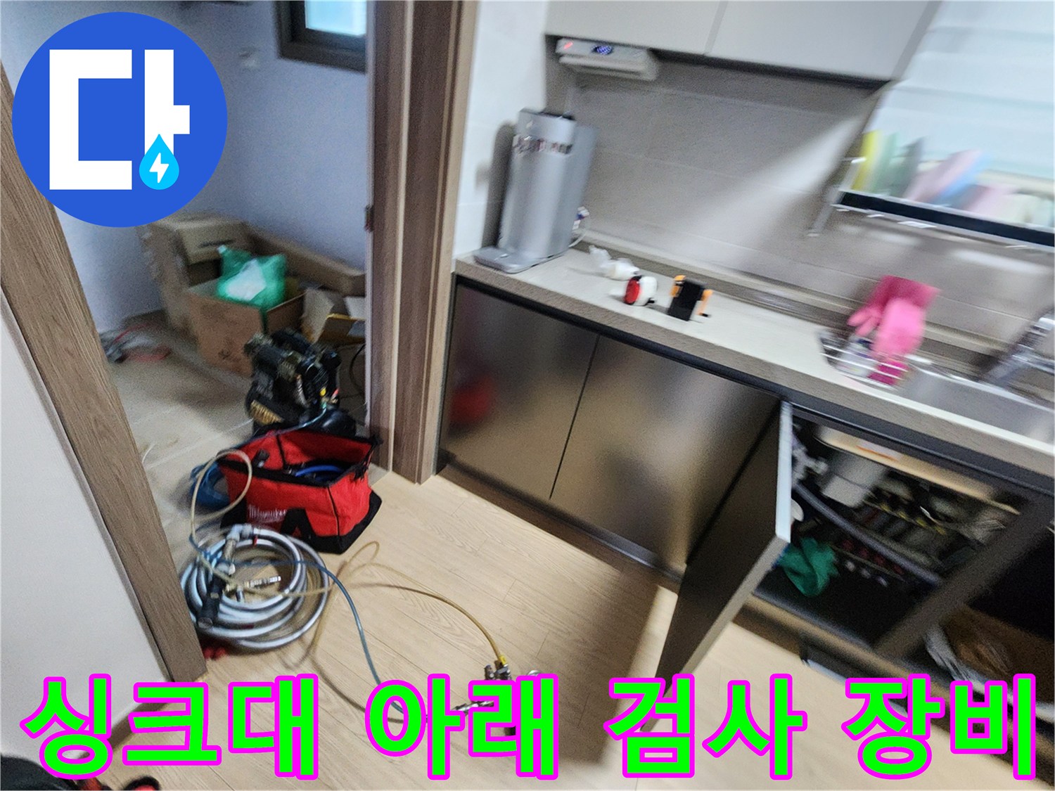 누수 원인 파악을 위해 싱크대 하부에 설치한 압력계와 호스