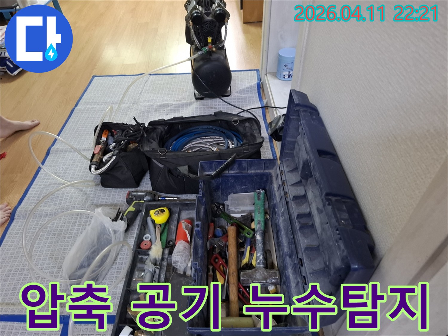 누수-탐지에-사용되는-압축-공기-주입-장비와-그-주변에-정돈된-다양한-수리-공구들