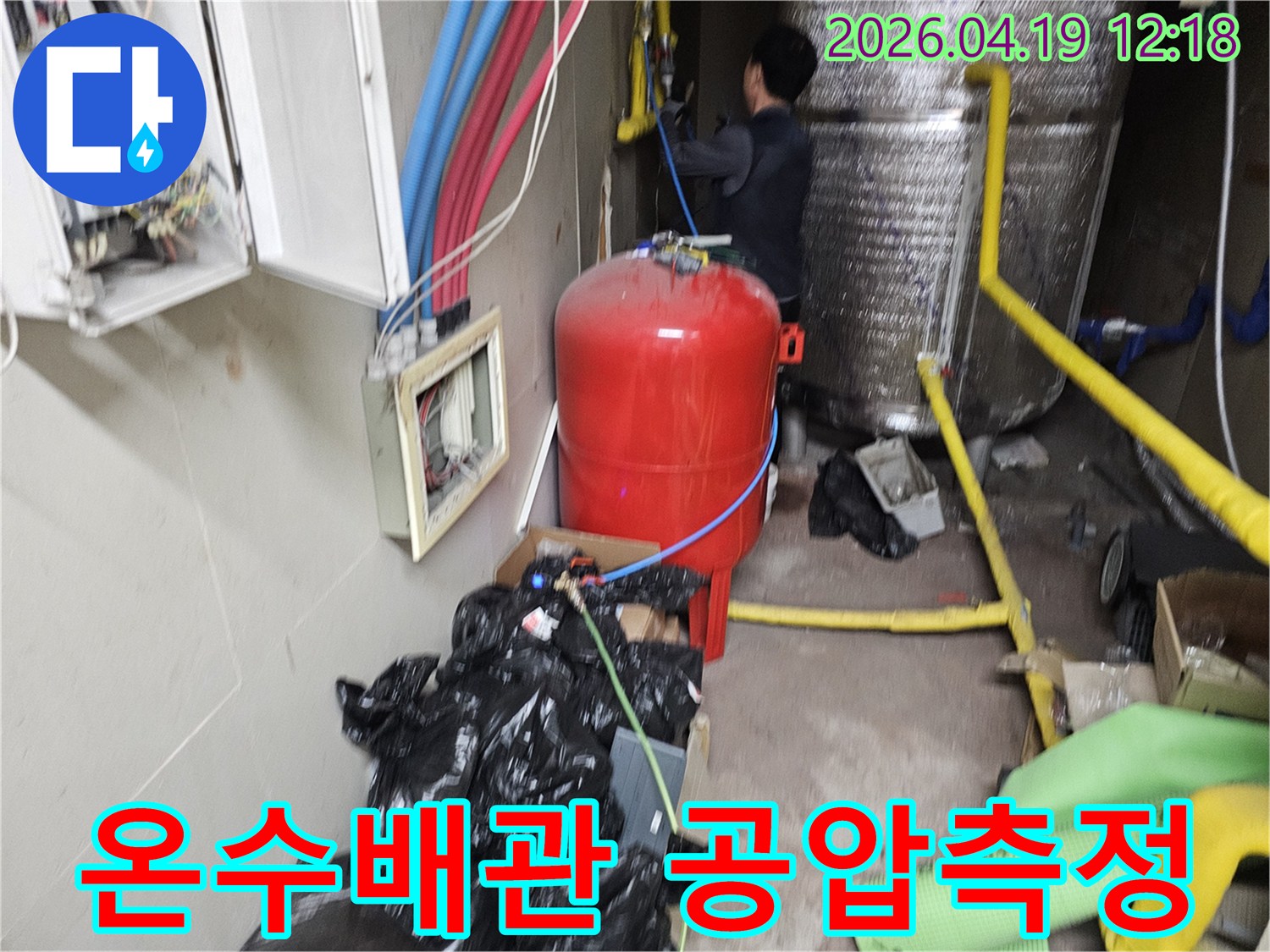 숙련된 엔지니어가 온수 배관의 누수 지점을 정확히 찾기 위해 공압 테스트를 진행하는 모습