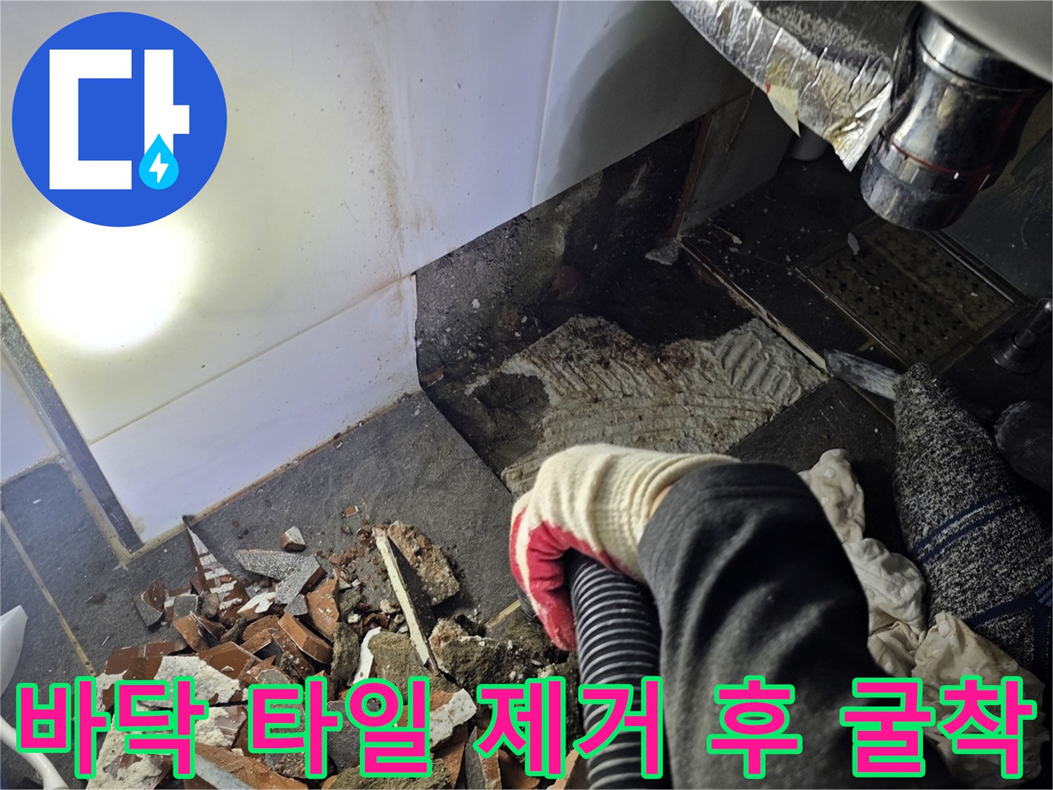 욕실 바닥 타일을 커팅하고 내부 배관 상태를 점상하기 위해 흙과 잔해를 파낸 사진입니다.