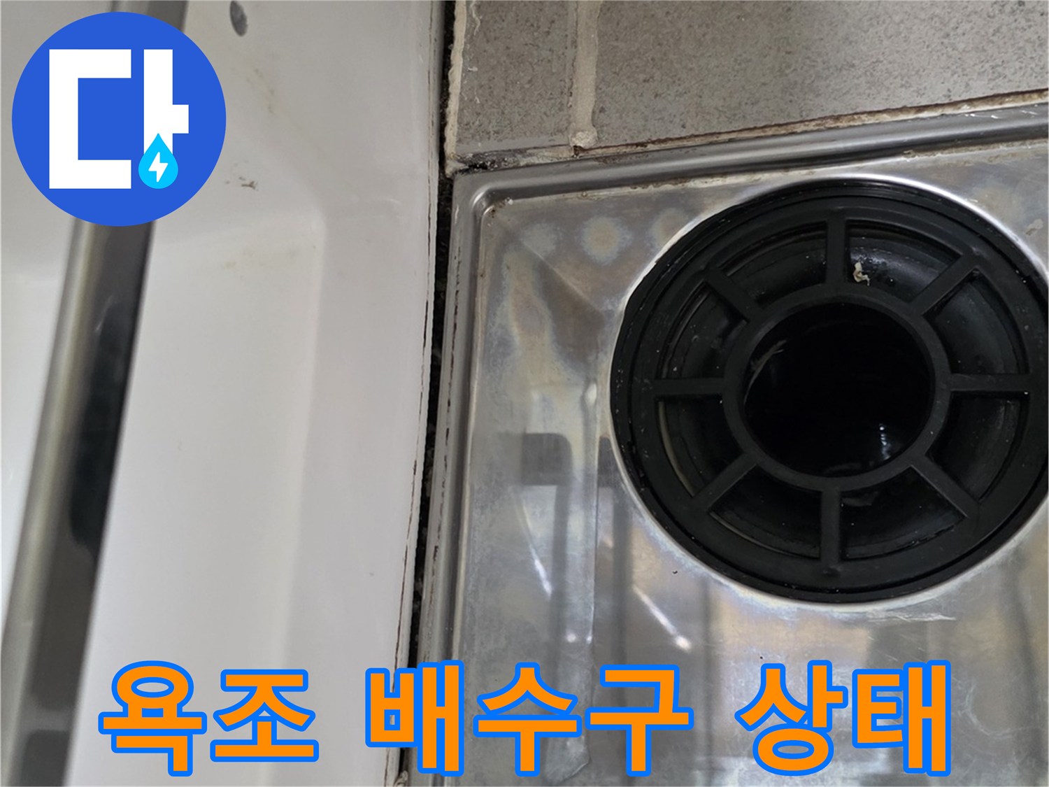 욕조와 벽면 사이 배수구 주변의 마감 상태를 보여주는 사진입니다.