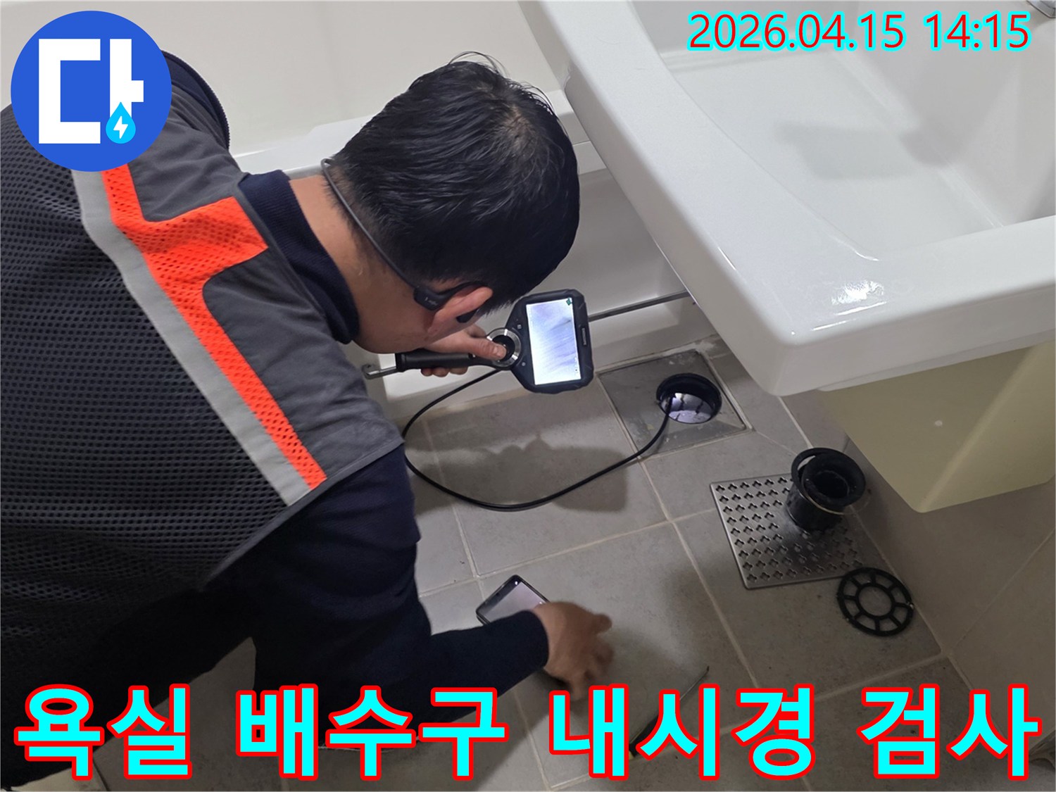 전문가가 욕실 배수구에-내시경 장비를 넣어-배관 내부의-누수 지점을-탐색하고 있습니다.