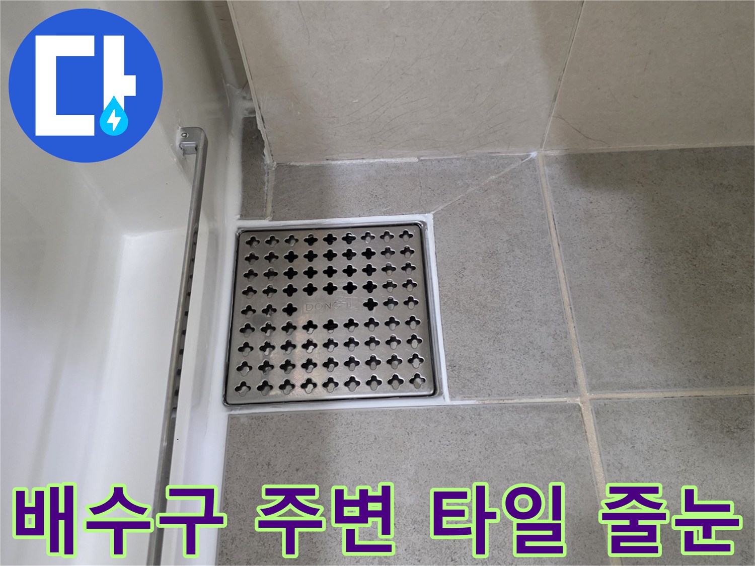 회색 타일과 금속 재질의 배수구 유가 마감 상세 사진