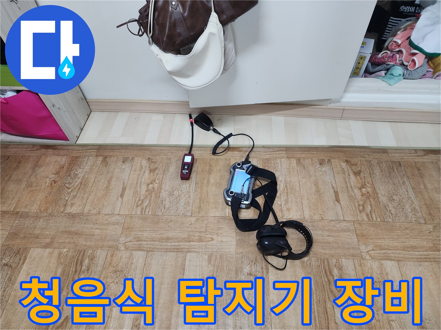 누수 지점을 찾기 위해 바닥에 놓인 청음식 탐지기와 헤드셋