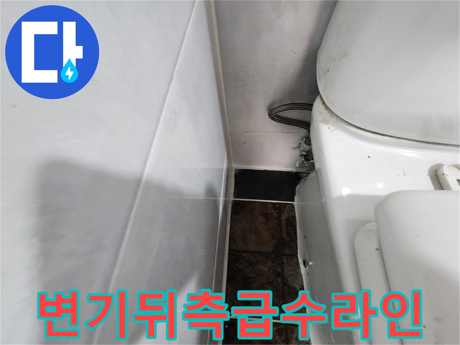 변기 뒤쪽 벽면 타일과 연결된 수도 배관의 근접 촬영