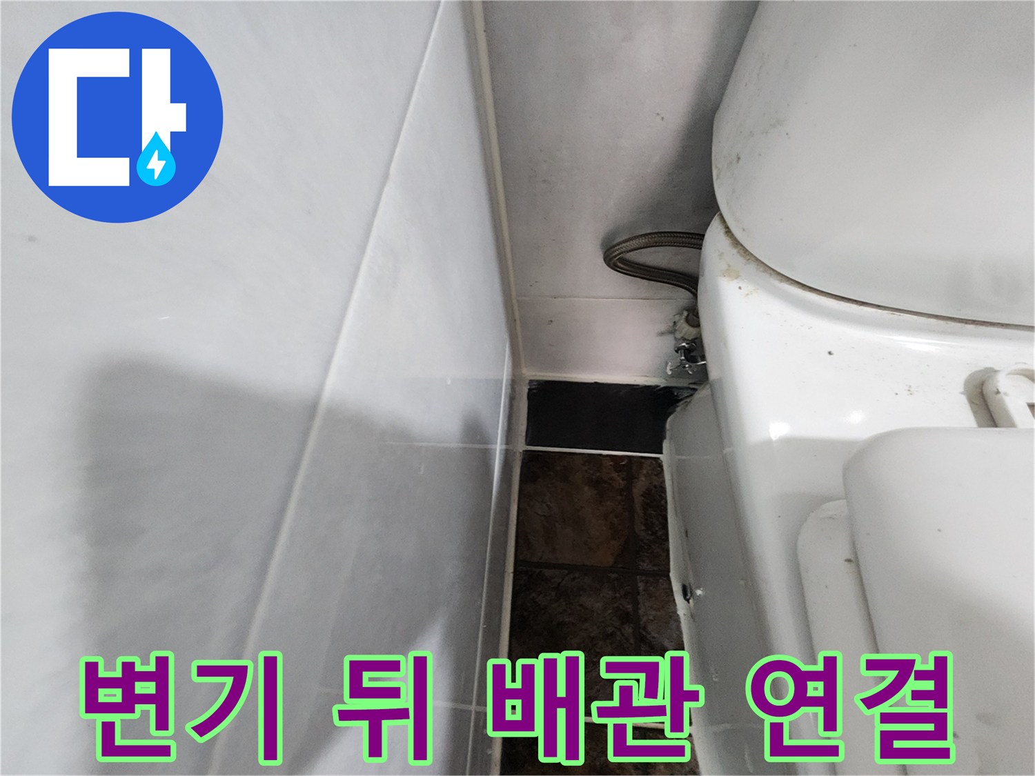 하얀 변기와 벽면 타일 사이의 급수 배관 모습