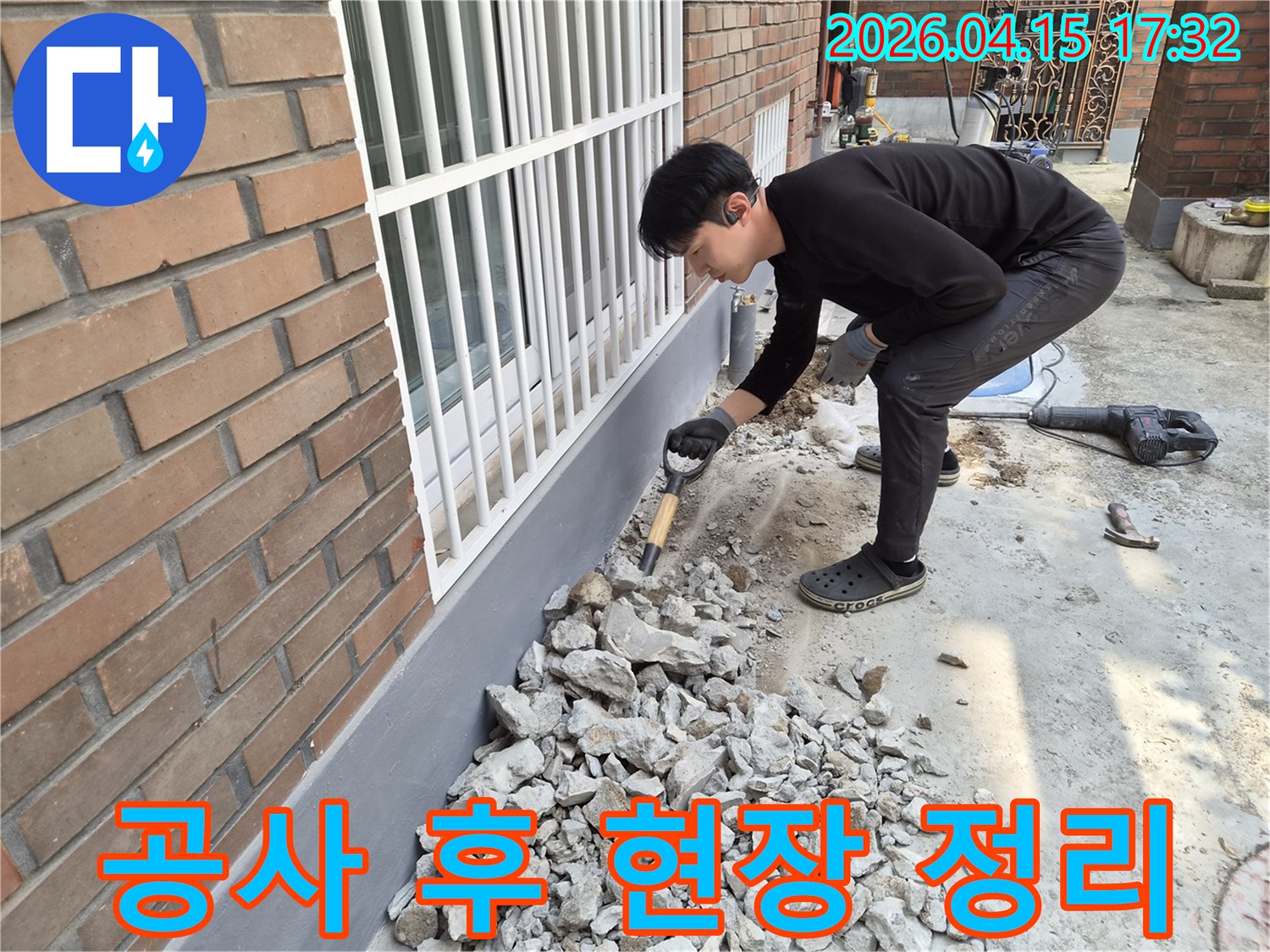 누수 보수 공사가 끝난 후-작업자가 현장을 깨끗하게 정리하고 있습니다