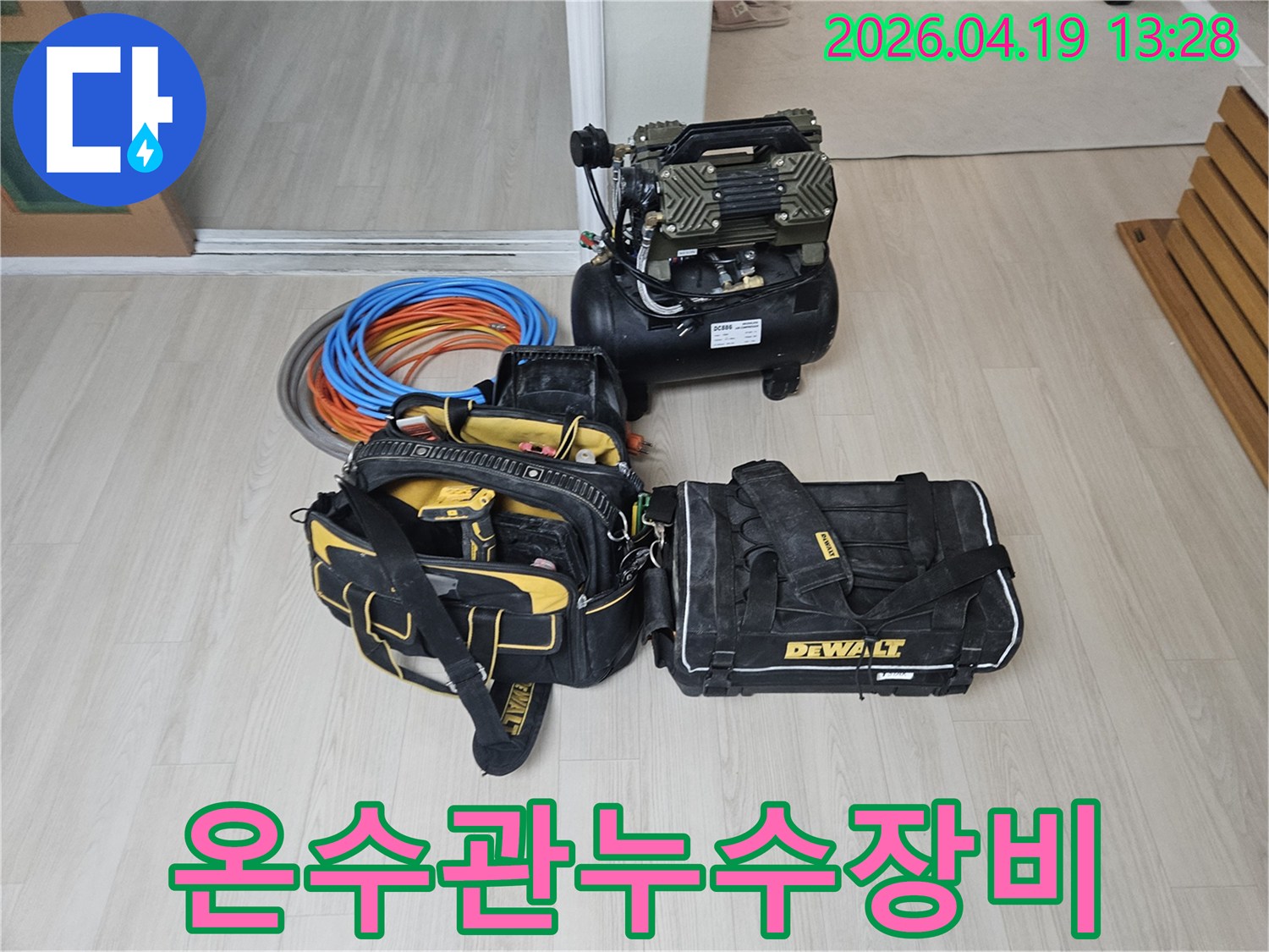온수관 누수 탐지를 위한-전문 장비들이 바닥에 준비되어 있습니다-에어 컴프레서와-정밀 공구 가방-그리고 온수 배관 자재들이 보입니다.