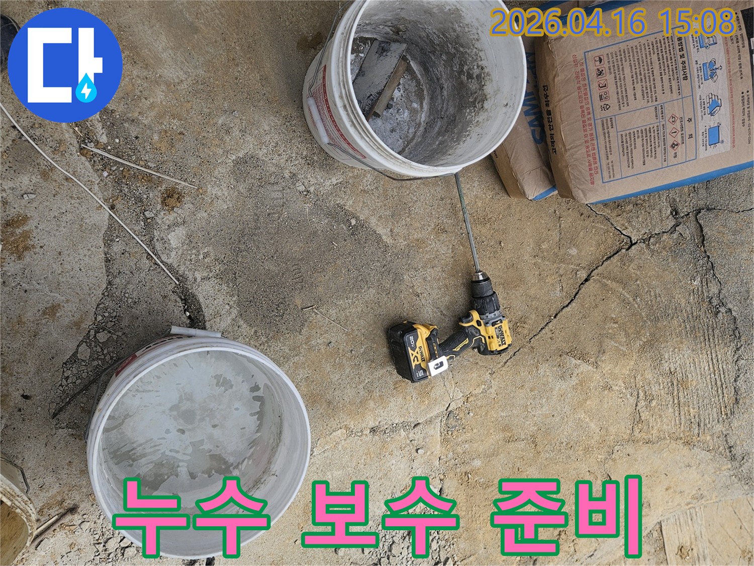 누수 공사 현장에서-시멘트 포대와-물을 섞을 믹서-그리고 물통이 준비된 모습