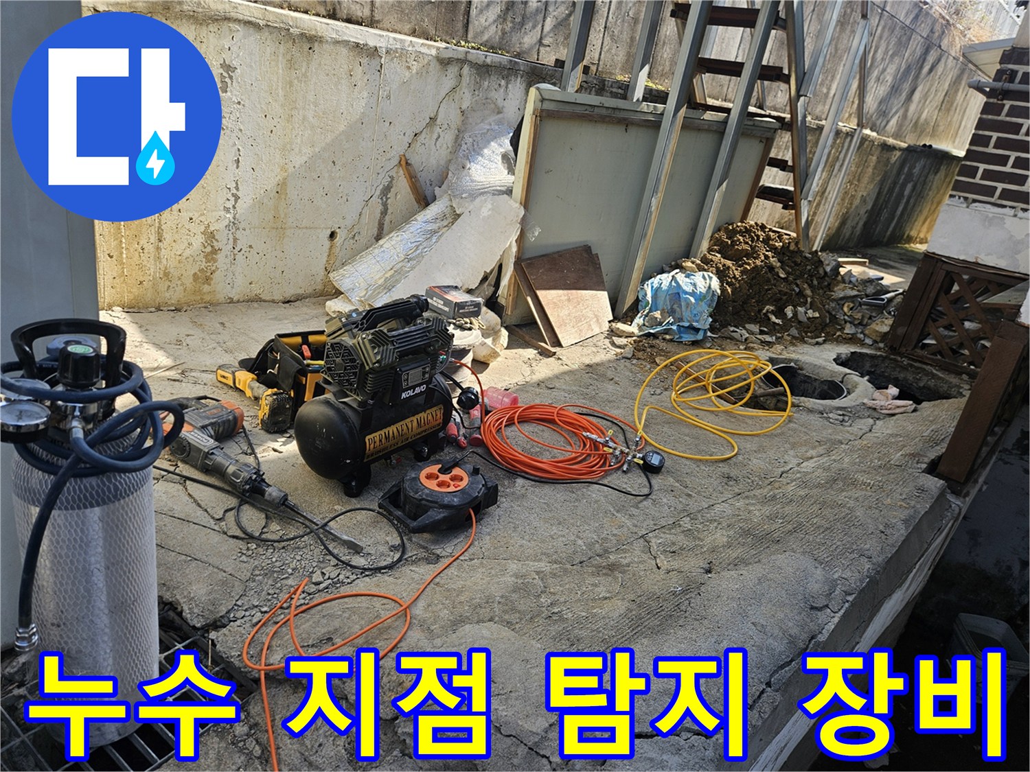 누수 공사를 위한-에어 콤프레셔-함마드릴-호스-전선릴 등-다양한 전문 장비들이-콘크리트 바닥 위에-정돈되어 있는-작업 준비 현장