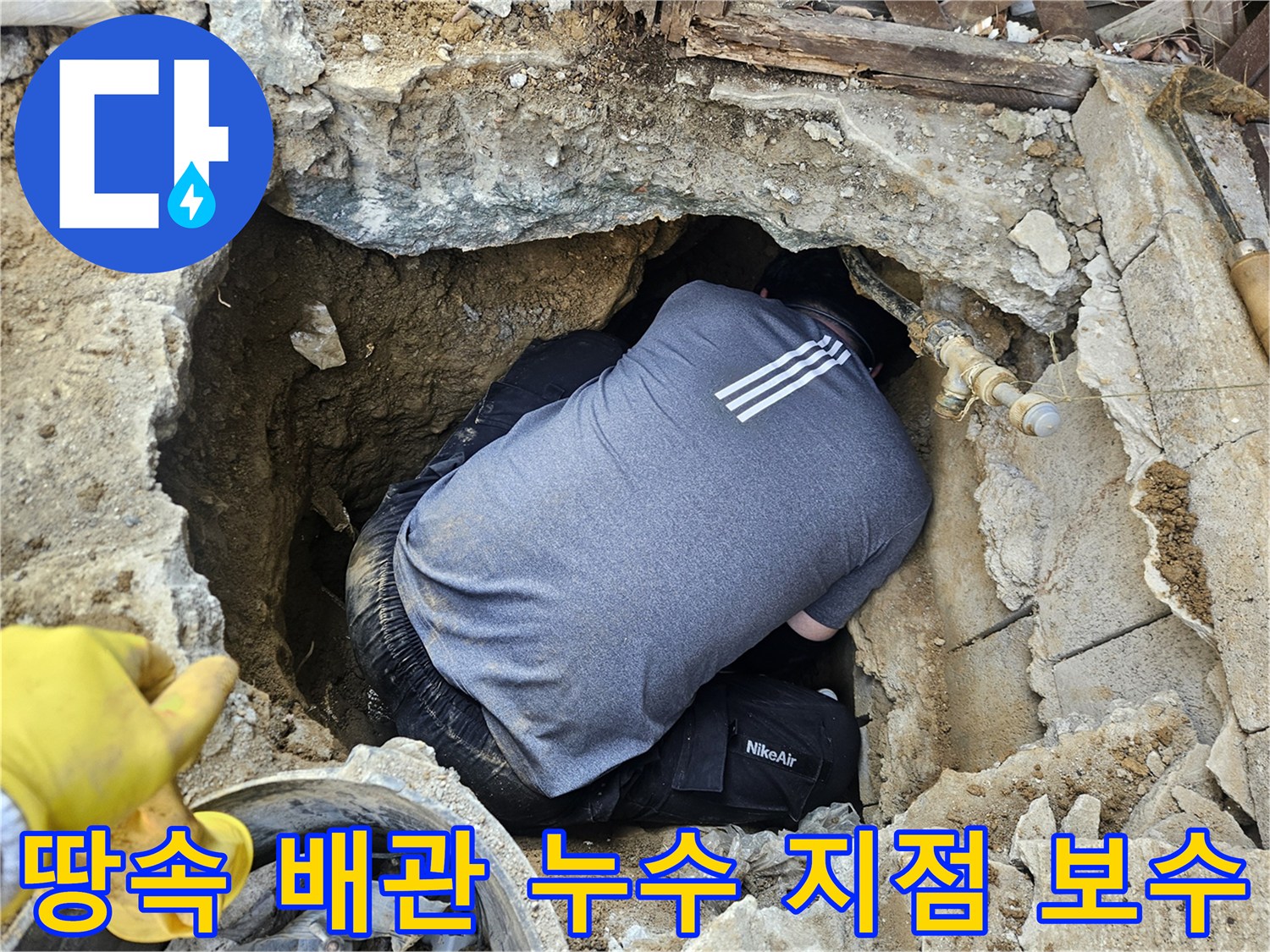숙련된 누수 엔지니어가-땅속에 매설된 배관의-누수 지점을 보수하기 위해-좁은 구덩이에서 작업하는 모습