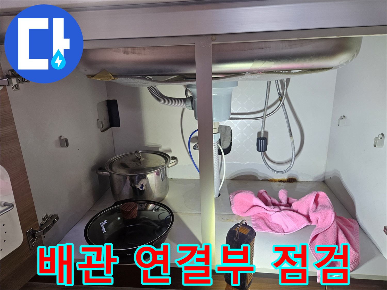 싱크대-하부의-배관-연결-부위에서-누수-여부를-정밀하게-점검하는-모습을-담은-사진입니다