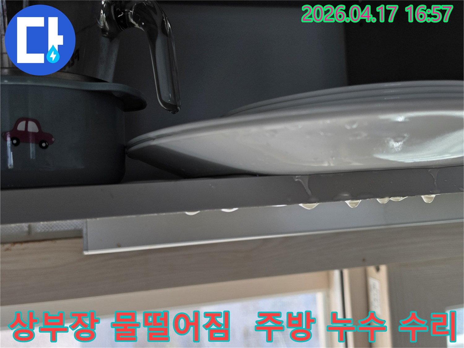 용인시 기흥구 효성해링턴플레이스 주방 상부장 아래 선반에서 물이 떨어지는 누수 현장을 보여주며-전문가의 수리가 필요한 이미지입니다.