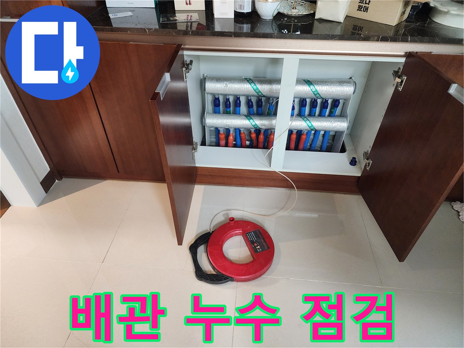 보온재로 감싸진 다수의 배관과 바닥의 붉은색 계측 장비