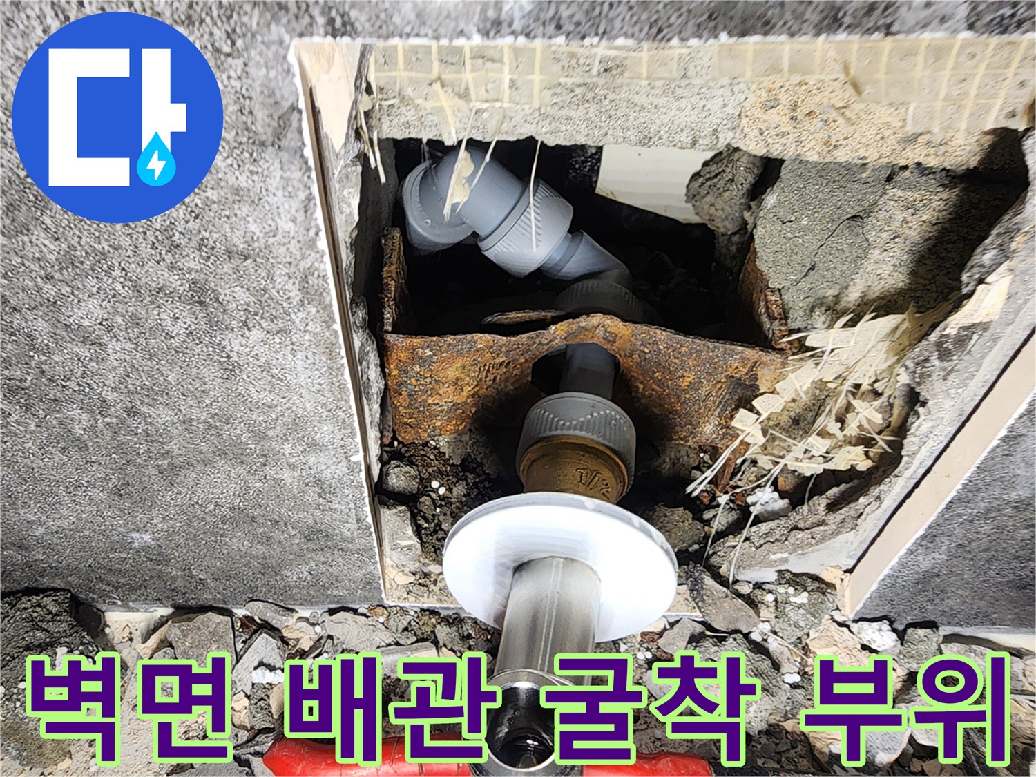 타일을 제거하여 노출시킨 화장실 내부 배관 연결부