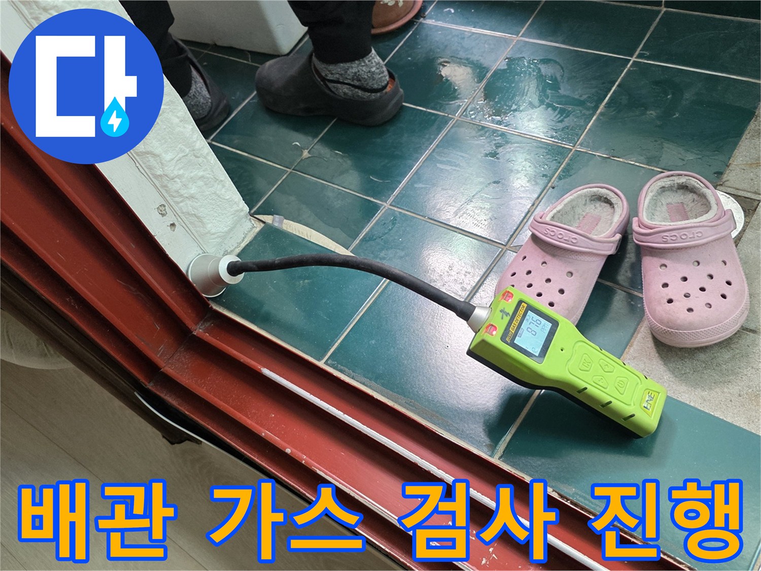 초록색 가스 탐지기를 배관 연결 부위에 대고 누설 여부를 확인하고 있습니다.