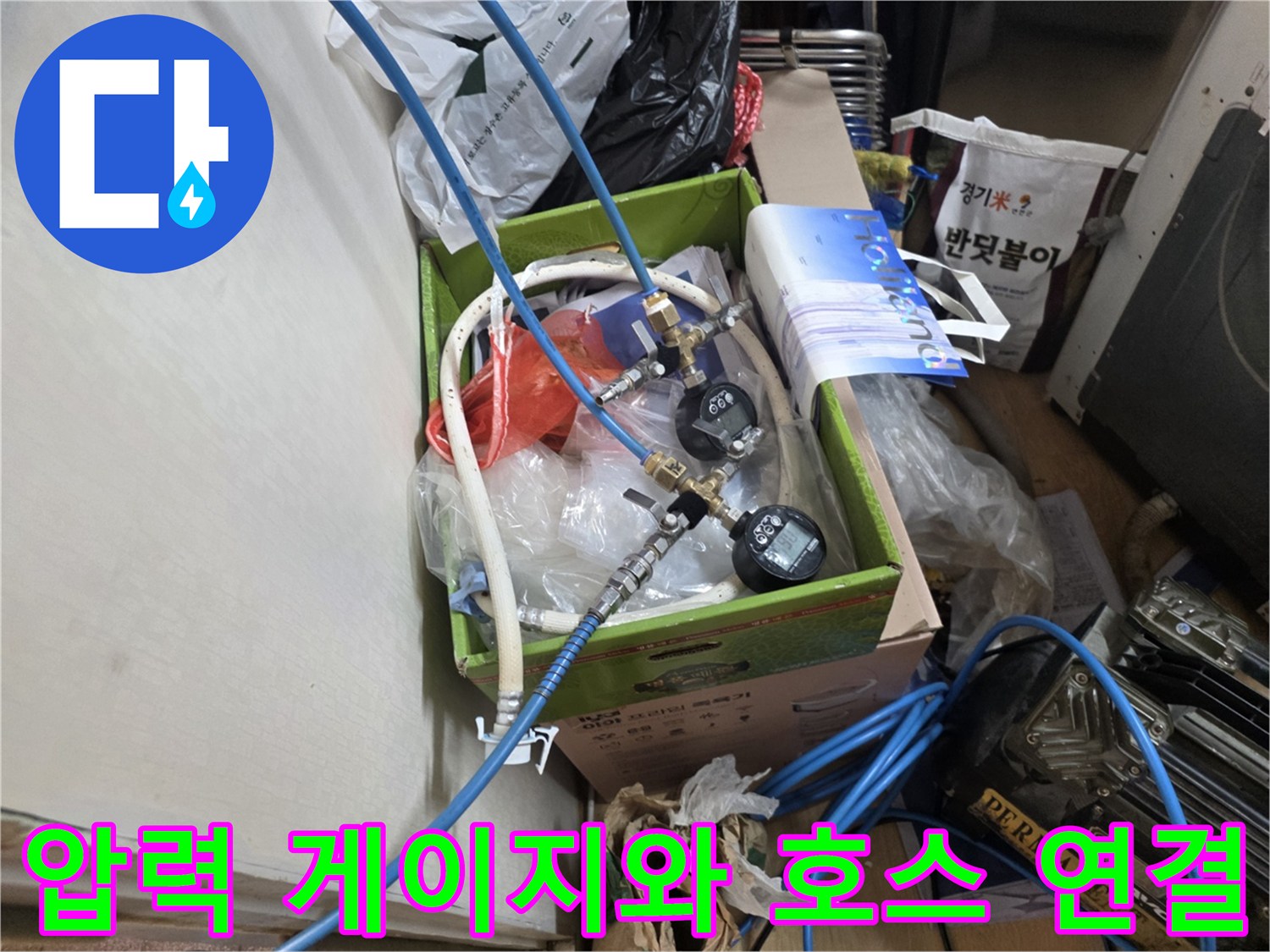 배관의 압력을 측정하기 위해 설치된 파란색 호스와 게이지 장비