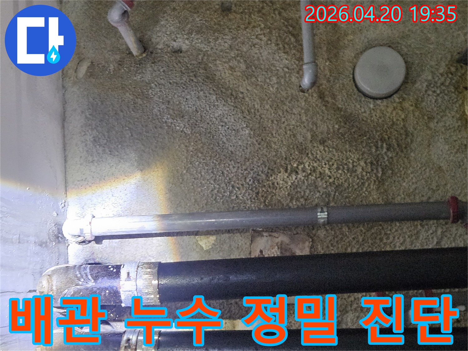 손전등으로 비춘-벽면의 배관 주변에서-물기가 확인되는-누수 탐지 현장의-모습입니다.