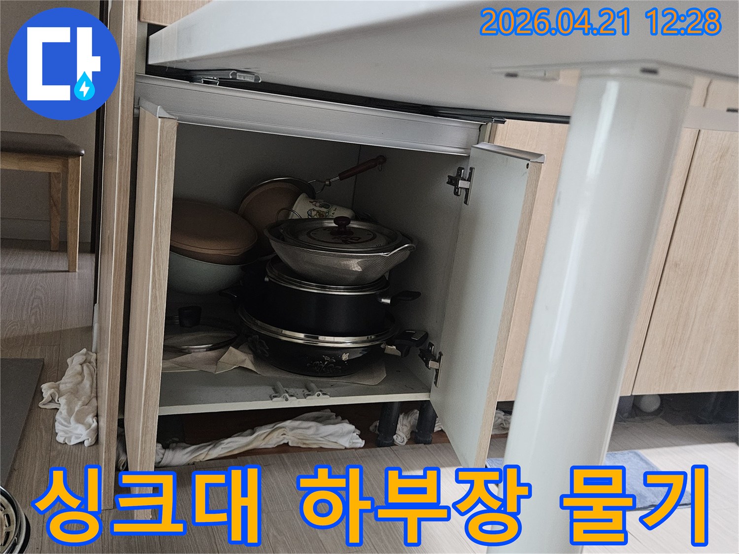 싱크대 하부장 내부에서 발견된-물기로 젖은 주방용품과-배관 노후로 인한 누수 현장