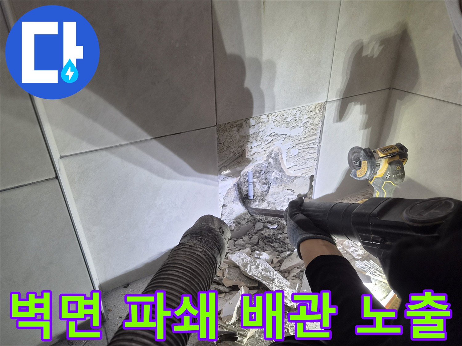 누수 발생 배관을 찾아내기 위해-벽면 타일과 콘크리트를 파쇄하는-전문가의 작업 모습입니다.