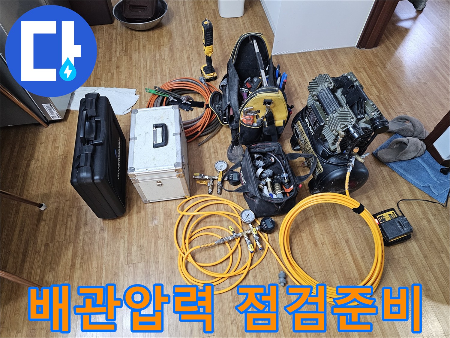 누수 탐지를 위한-공압 테스트 장비와-연결 호스들이-바닥에 놓여-작업 준비를-마친 상태입니다